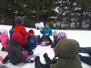 groupe d'enfant et un adultes assis dans la neige