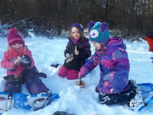 trois enfants assis dans le neige